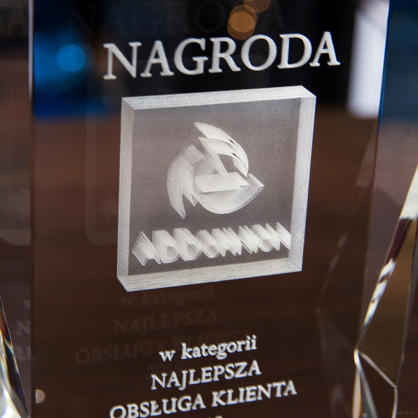 Szklana nagroda z grawerunkiem 3D logo ADDopinion na podstawce - zbliżenie
