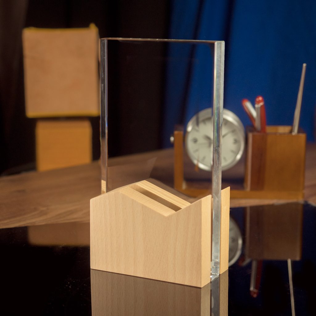Statuetka szklana z elementami z drewna o wymiarach 22x12x6 cm w kształcie ramki z prostymi krawędziami. Doskonała do grawerowania w niej zdjęć 2D oraz modeli 3D o stosunkowo małej głębokości takich jak logotypy, czy odznaki (wymiary obszaru przeznaczonego do grawerunku: 12x12x2 cm).

Połączenie drewna ze szkłem tworzy bardzo prestiżową statuetkę, która świetnie będzie się prezentować w biurze lub jako element wystroju recepcji.